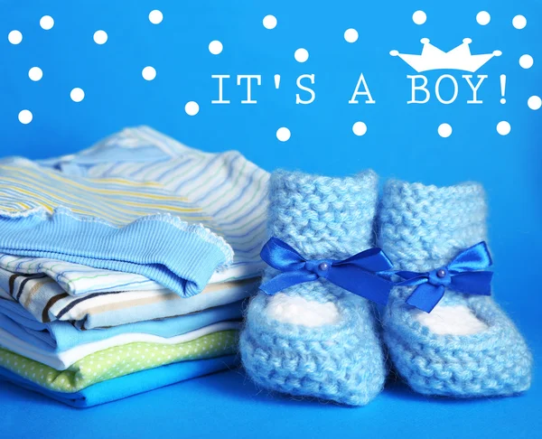 stock image Pile of baby clothes on blue background