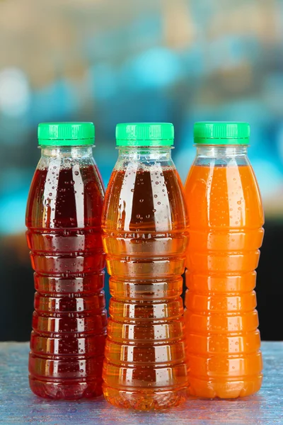 Assortimento di bottiglie con succhi di frutta gustosi su sfondo brillante — Foto Stock