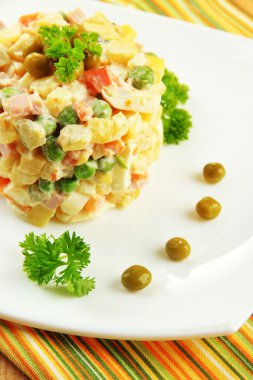 Rus salatası geleneksel ahşap arka plan üzerinde renkli peçete üzerinde olivier