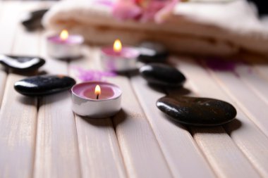 renkli ahşap zemin üzerinde güzel çiçeklenme ile natürmort orkide çiçek, havlu ve spa taşlar