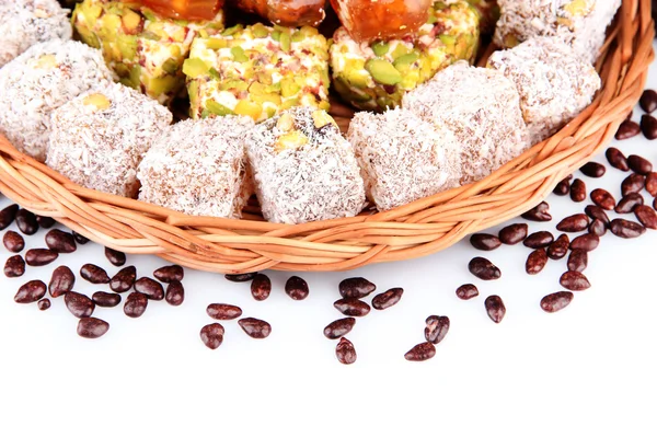 Tasty oriental sweets on wicker tray, isolated on white — Stock Photo, Image