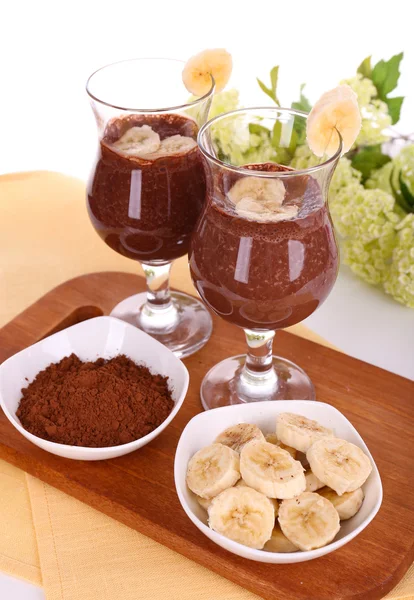 Drinkar med banan och choklad på bordet på vit bakgrund — Stockfoto