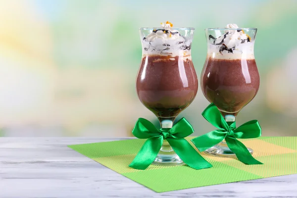 Sobremesa saborosa com chocolate, creme e molho de laranja, em guardanapo. na mesa de madeira, no fundo claro — Fotografia de Stock