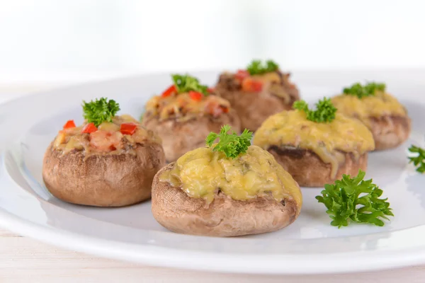 Stuffed mushrooms on plate on table on light background — Stock Photo, Image