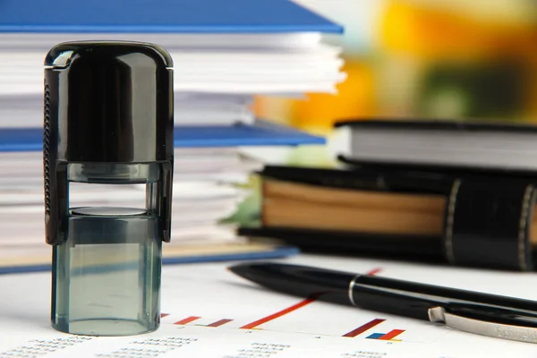 Stempel met blocnotes en papieren op tafel — Stockfoto