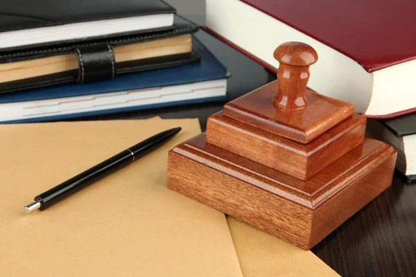Wooden stamp with notepads and books on table — Stock Photo, Image