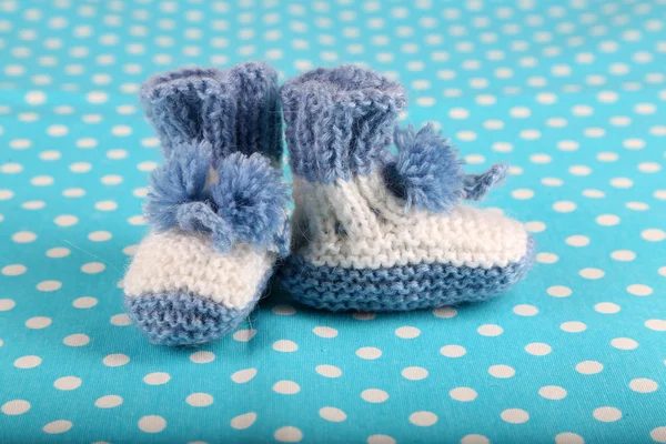 Crocheted booties for baby, on color background — Stock Photo, Image