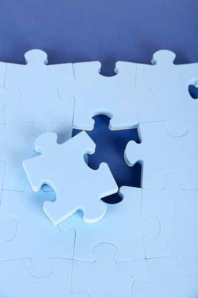 Last piece of jigsaw puzzle, close-up, on blue background — Stock Photo, Image