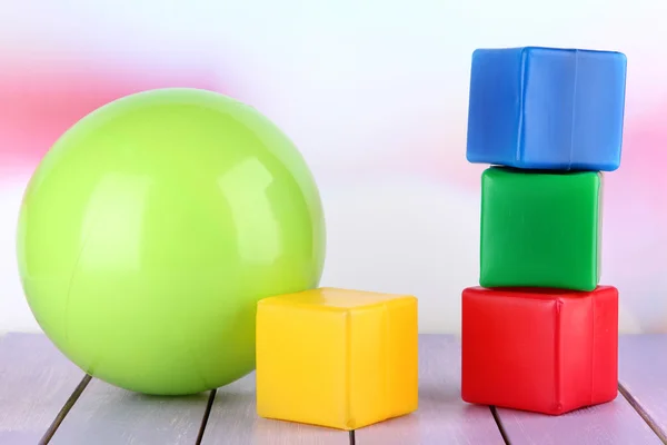 Bright ball and colorful cubes on table on bright background — Stock Photo, Image