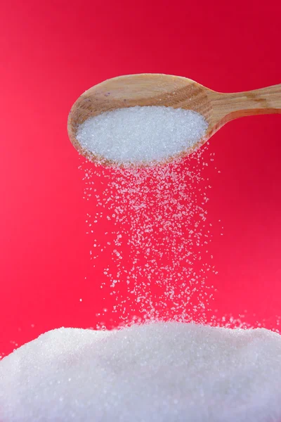 Sugar on red background — Stock Photo, Image