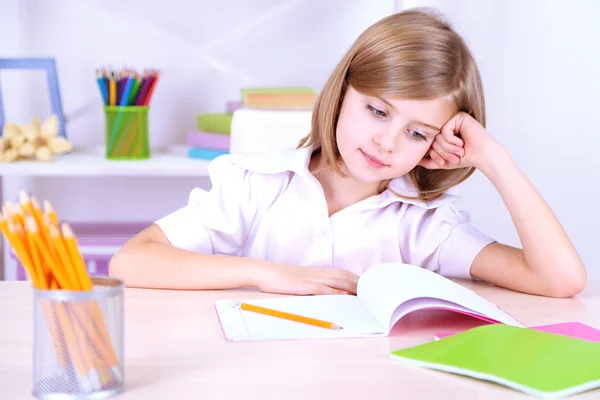 Niña sentada en el escritorio en la habitación —  Fotos de Stock