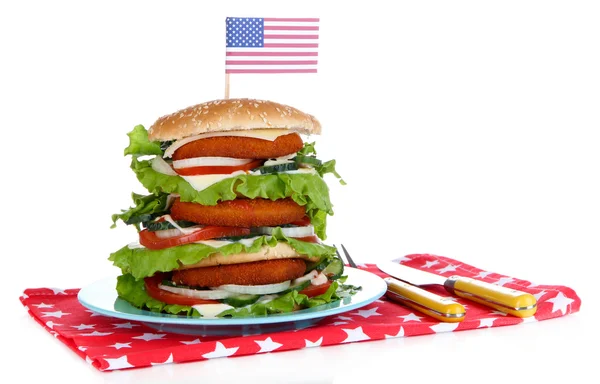 Composition with huge burger on color plate and USA flag, isolated on white — Stock Photo, Image