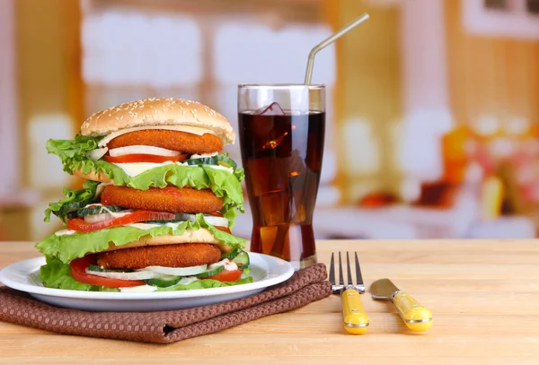 Velký burger na barevné desce a sklenici studené nápoje, na světlé pozadí — Stock fotografie