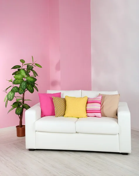 在房间里粉红色墙背景上的白色沙发 — 图库照片