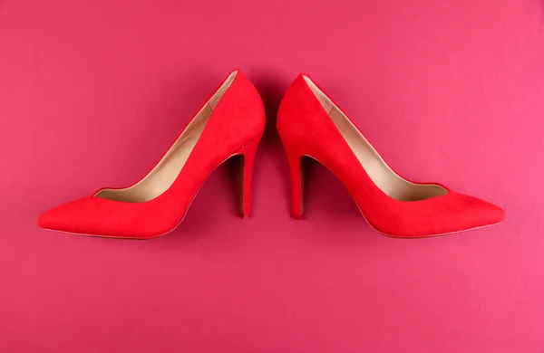 漂亮的红色女性鞋子，粉红色的背景上 — 图库照片
