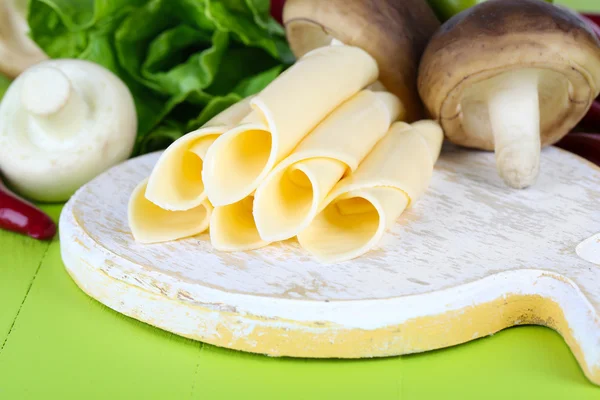 Сливочный сыр с овощами и зеленью на деревянном столе крупным планом — стоковое фото