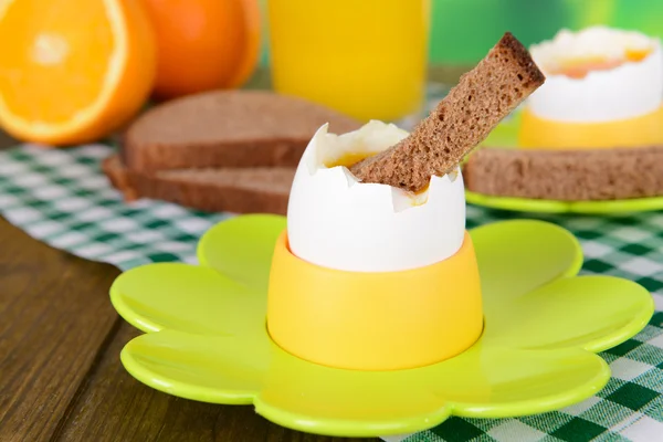 Boiled eggs in egg cups on table on bright background — Stock Photo, Image