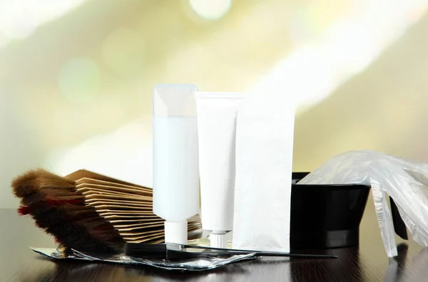 Hair dye kit and hair samples of different colors, on wooden table, on light background — Stock Photo, Image