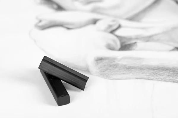 Fekete szén támaszkodva elszigetelt fehér kép — Stock Fotó