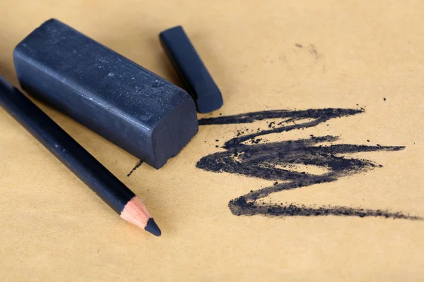 Černá kreslicí uhly a tužka na papíře — Stock fotografie