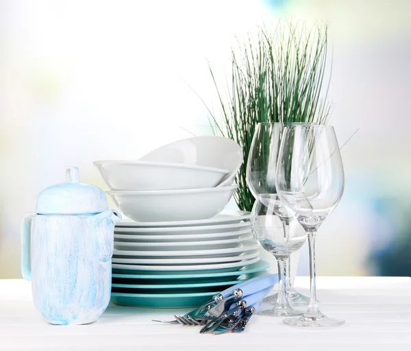 Piatti puliti sul tavolo su sfondo luminoso — Foto Stock