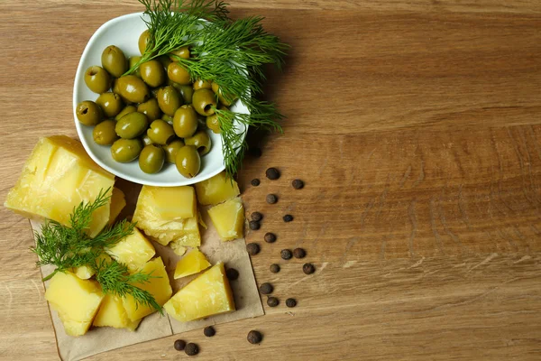 Parmesan peyniri, taze otlar ve zeytin ahşap zemin üzerinde — Stok fotoğraf