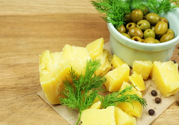Сыр пармезан, свежие травы и оливки на деревянном фоне — стоковое фото