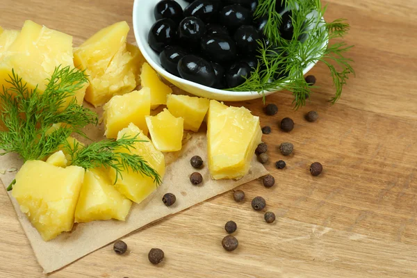Parmezaanse kaas, verse kruiden en olijven op houten achtergrond — Stockfoto