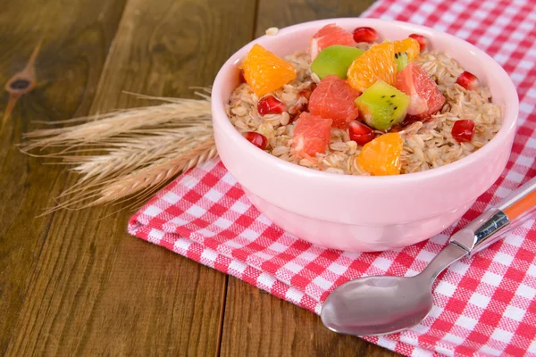 Delicious oatmeal with fruit in bowl on table close-up — Stock Photo, Image