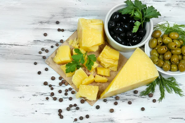 Τυρί παρμεζάνα, φρέσκα βότανα και ελιές σε ξύλινα φόντο — Φωτογραφία Αρχείου