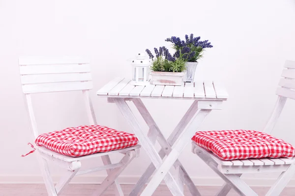 Sedie da giardino e tavolo con fiori su sfondo bianco — Foto Stock