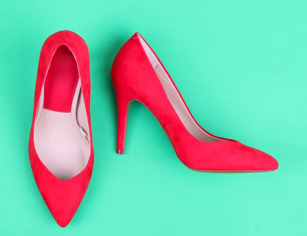 Mooie rode vrouwelijke schoenen, op groene achtergrond — Stockfoto