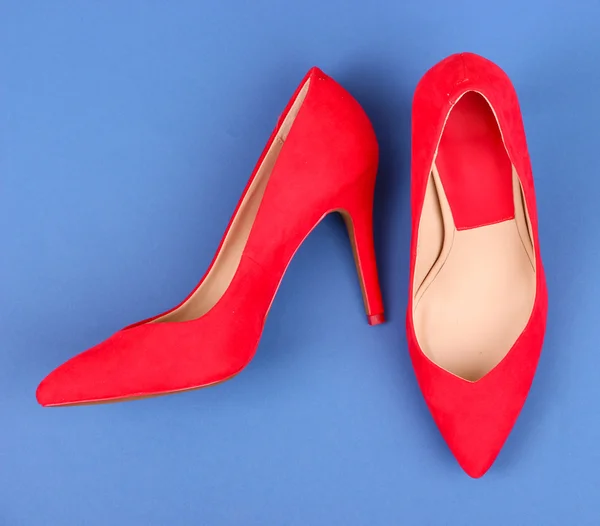 Beautiful red female shoes, on blue background — Stock Photo, Image