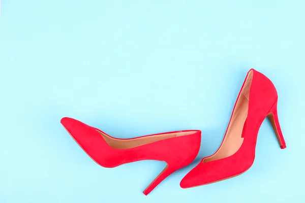 Mavi arka plan üzerinde güzel kırmızı kadın ayakkabı — Stok fotoğraf