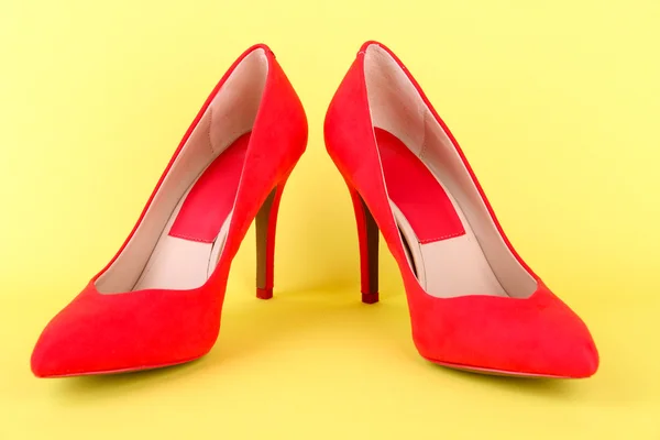 Hermosos zapatos femeninos rojos, sobre fondo amarillo — Foto de Stock