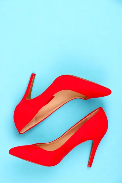 Beautiful red female shoes, on blue background — Stock Photo, Image