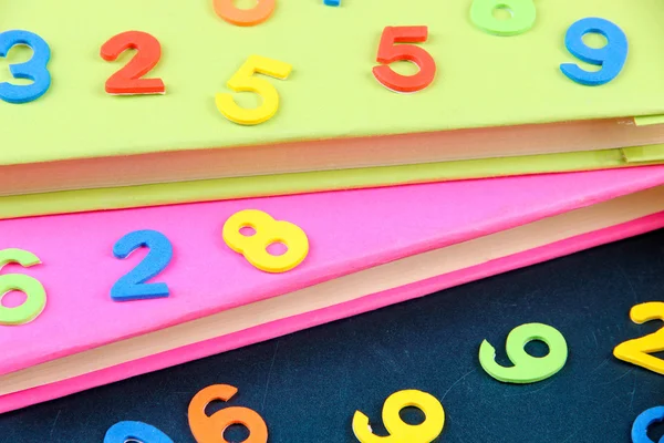 Bunte Zahlen und Bücher auf der Schulbank Hintergrund — Stockfoto