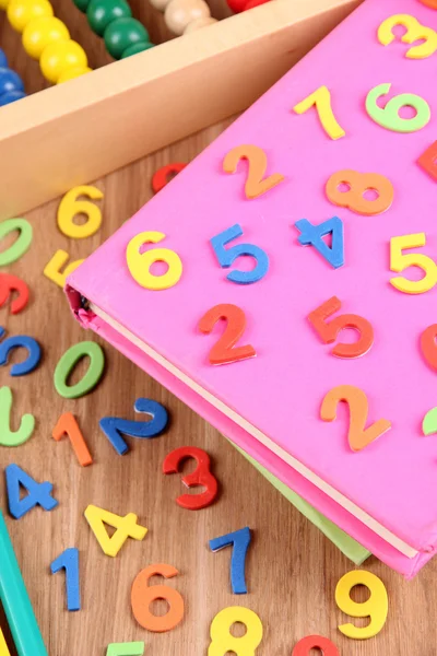 Numéros colorés, abaque, livres et marqueurs sur fond en bois — Photo