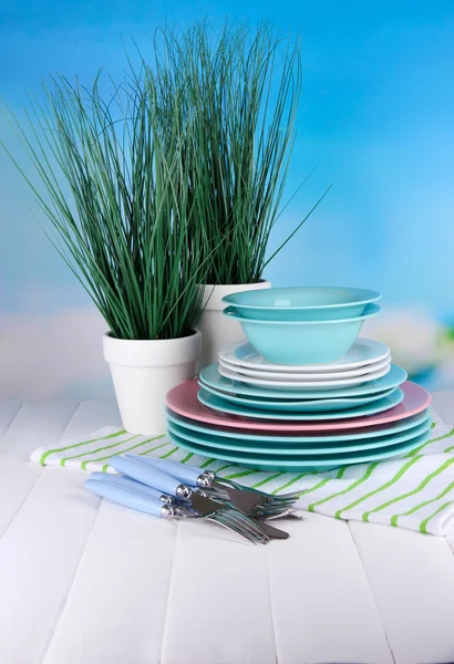 Sauberes Geschirr mit Blumen auf Holztisch vor natürlichem Hintergrund — Stockfoto