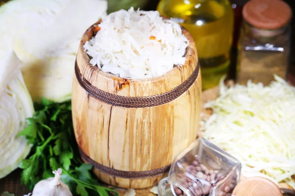 Composition au chou frais et mariné (choucroute) en fût de bois, sur fond de table en bois — Photo