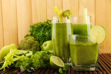 Yeşil sebze suyu ve bambu hasır ahşap arka plan üzerinde sebze bardak