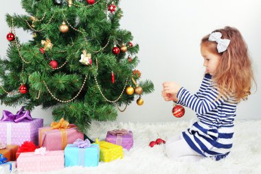 küçük kız odasında baubles ile Noel ağacı süsleme