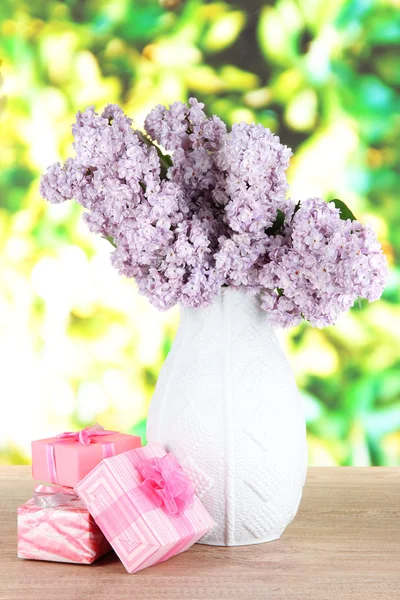 Bellissimi fiori lilla sul tavolo su sfondo luminoso — Foto Stock