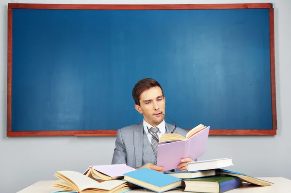 Jonge leraar zitten in school klas — Stockfoto