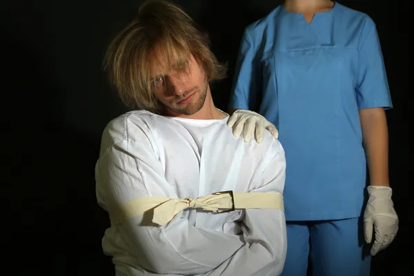 Homem mentalmente doente em camisa de força sobre fundo preto — Fotografia de Stock