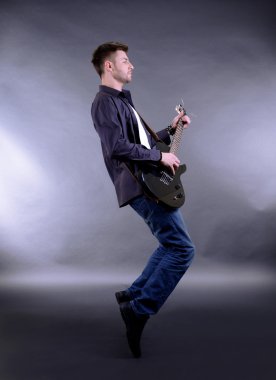 genç müzisyen üzerine beyaz izole gitar çalmak