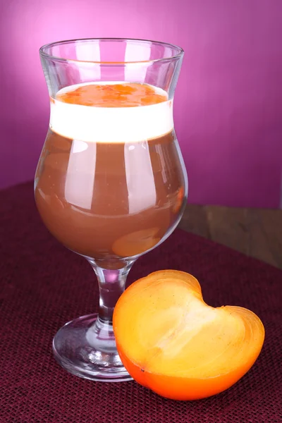 Dessert choklad och persimon på bordet på lila bakgrund — Stockfoto