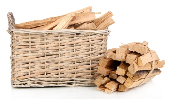 Stapel brandhout in rieten mand geïsoleerd op wit — Stockfoto
