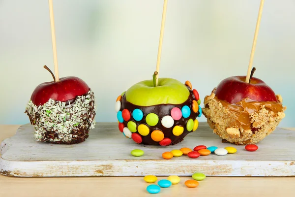 Candied apples on sticks on bright background — Stock Photo, Image