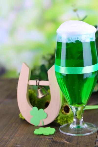 Glass of green beer and horseshoe for St Patricks day on wooden table close-up — Stock Photo, Image